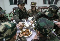在上海西点军事冬令营的营地餐厅里孩子们狼吞虎咽的吃着饭菜